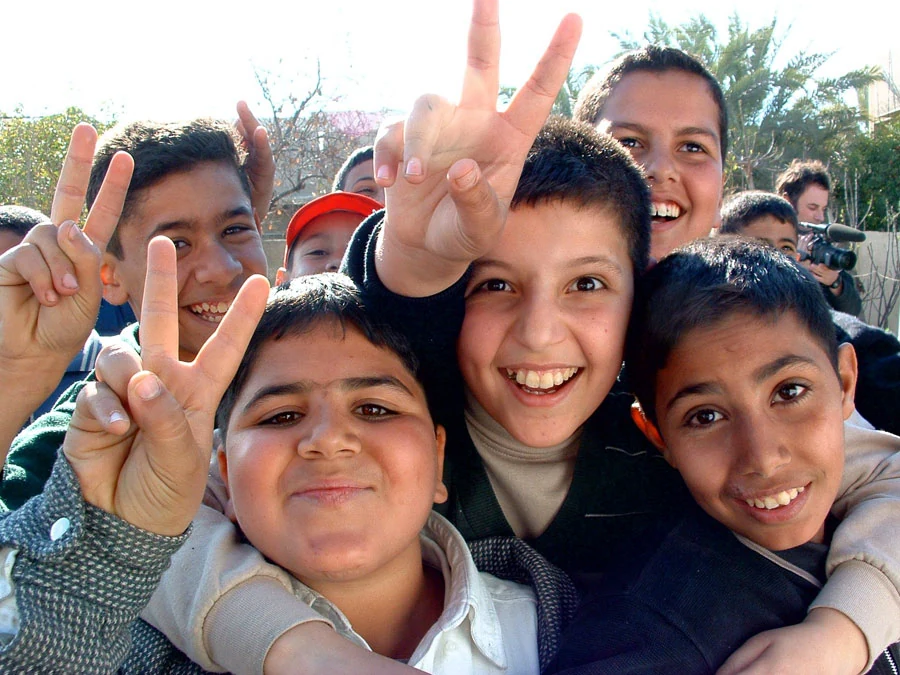 Iraqi boys flashing peace signs and smiling for the camera