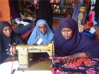Refugee women learning to use a sewing machine through the Foundation's livelihood program